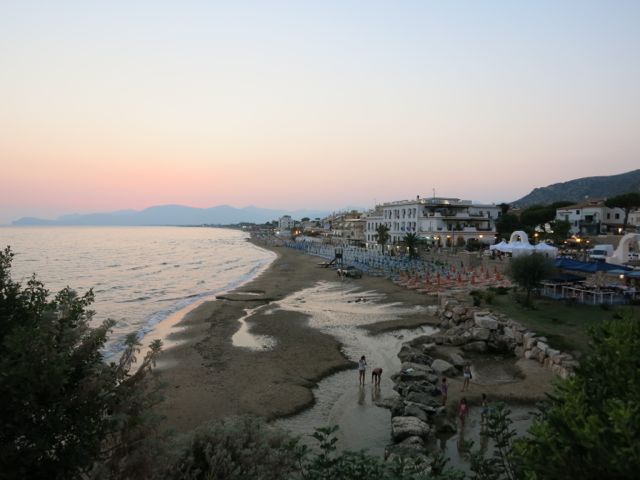The northern beach, with cold fresh spring in foreground. Hotel Aurora on the right. 